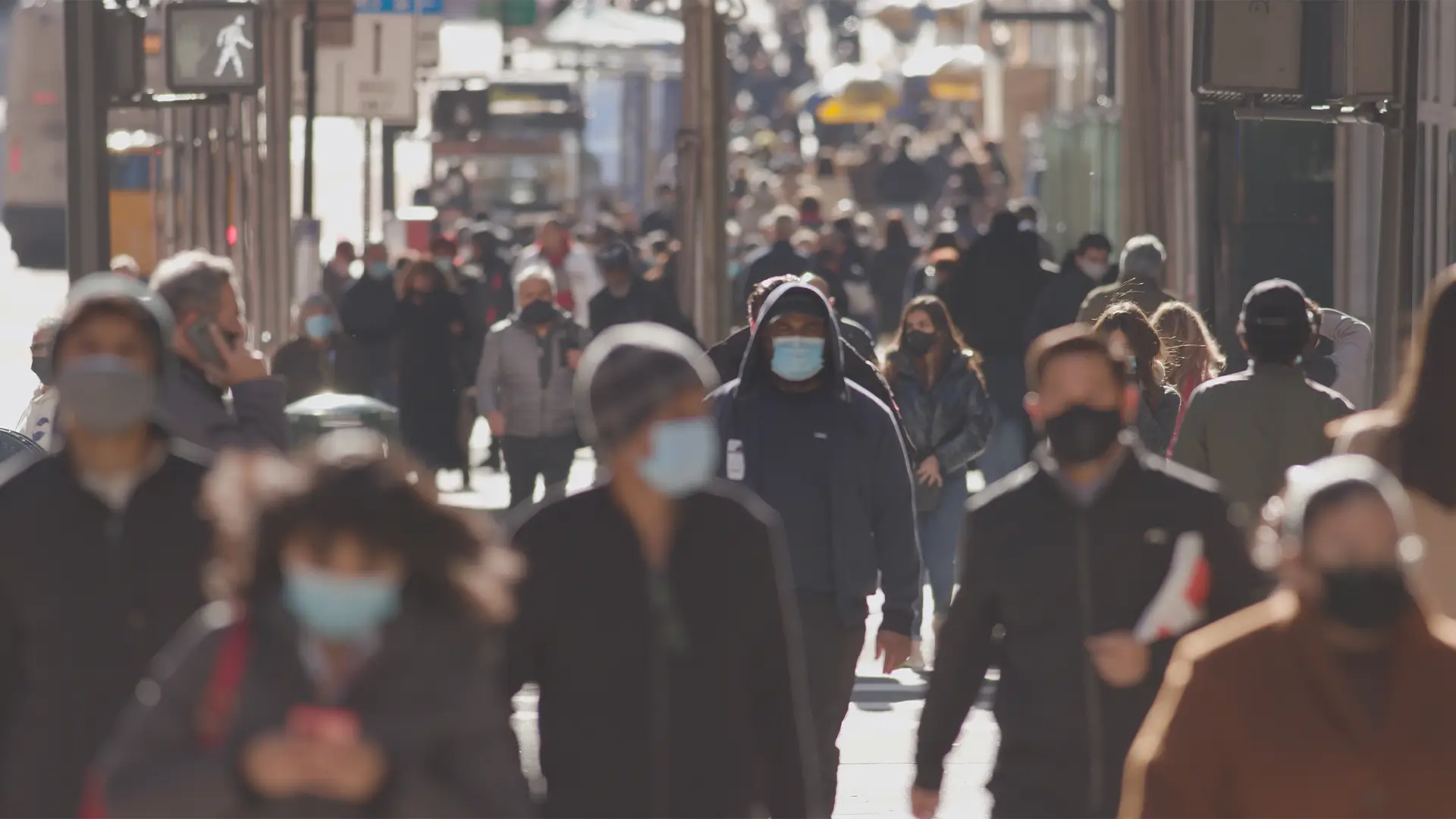 Menschen laufen mit Masken durch die Stadt